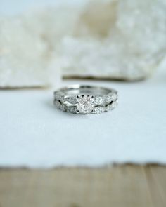 two wedding rings sitting next to each other on top of a white piece of paper