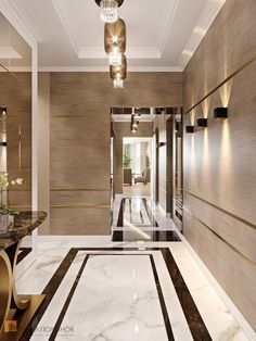 an elegant hallway with marble flooring and gold accents on the walls, along with two chandeliers