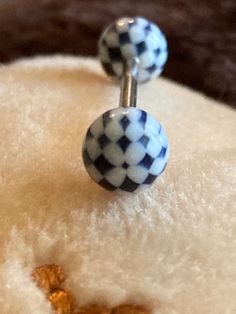 a pair of blue and white checkered ball earrings