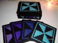 four coasters made out of crochet are sitting on a counter top, one is blue and the other is purple