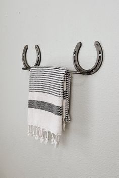 a towel hanging on a hook with two pairs of scissors attached to the wall next to it