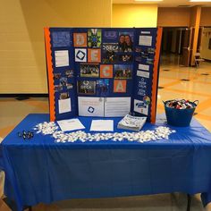 a blue table topped with a sign and bowl of popcorn