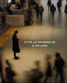 a man standing in the middle of a train station while looking at his cell phone