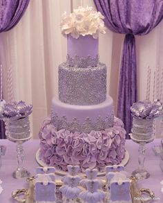 a purple and silver wedding cake on a table