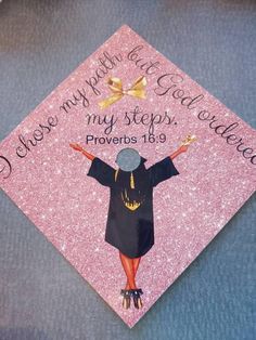 a pink graduation cap with an image of a woman in black and gold on it