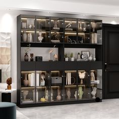 a living room filled with lots of black furniture and shelves covered in glass doors next to a white couch