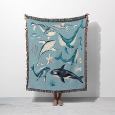 a woman standing in front of a blue blanket with dolphins and starfish on it