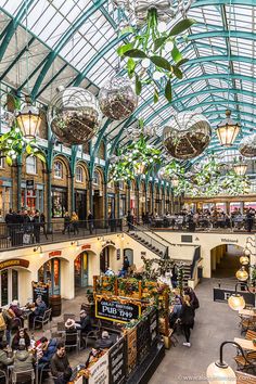 the inside of a shopping mall filled with lots of shops and people sitting at tables