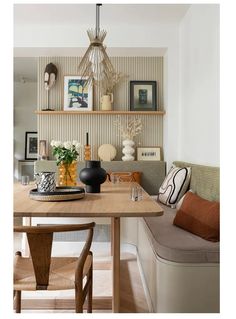 a dining room table with two chairs and a bench in front of the wall behind it