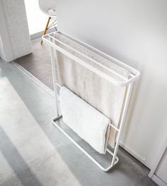 a white towel rack with two towels hanging from it's sides next to a door