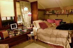 a bed room with a neatly made bed and lots of books on the shelf next to it