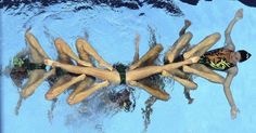 people are swimming in the water with their legs spread out to form a star shape