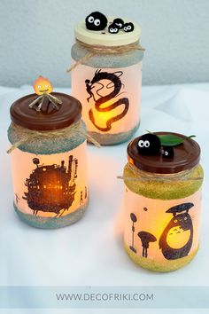 three mason jars decorated with googly eyes and cartoon characters are sitting on a white surface