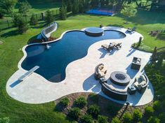 an aerial view of a backyard with a pool and fire pit