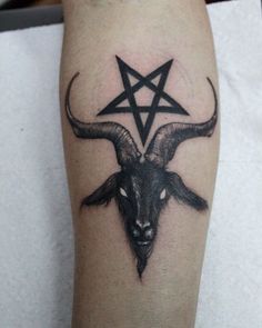 a goat head with a pentagramil tattoo on it's leg