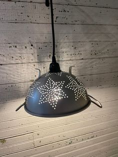 a light that is on top of a wooden floor with white paint and dots painted on it