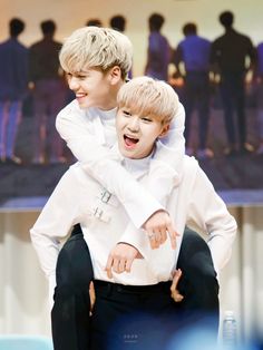 two young boys sitting on top of each other