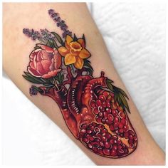 a heart shaped tattoo with flowers on it