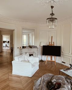 a living room filled with furniture and a flat screen tv on top of a wooden floor