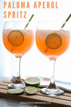 two wine glasses filled with paloma aperol spritz next to sliced cucumbers