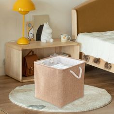 a bedroom with a bed, nightstand and storage bin