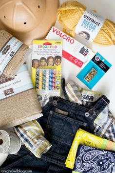 an assortment of clothing and accessories laid out on top of a white surface with a piggy bank in the background