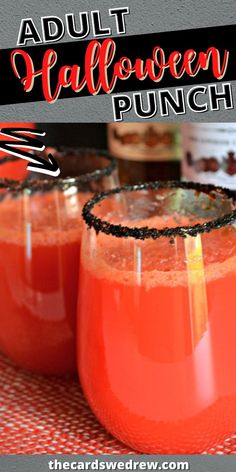 two glasses filled with halloween punch sitting on top of a table