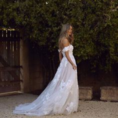 a woman in a wedding dress standing outside