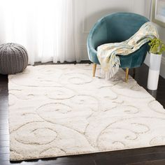 a white rug in a living room with a blue chair