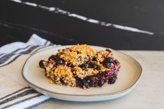 a white plate topped with blueberry crumble cake