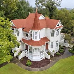 an aerial view of a large white house with red roofing and two story windows