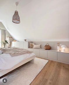 a bedroom with white walls and wooden flooring in the middle of it is shown