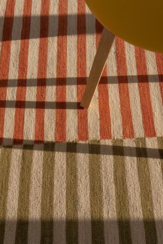 an orange chair sitting on top of a checkered rug next to a wooden table