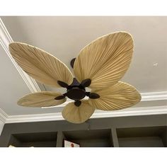 a ceiling fan with two large leaves on it's blades hanging from the ceiling