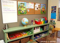 a green shelf filled with lots of books next to a whiteboard and pictures on the wall