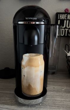 an espresso machine with latte art on the bottom and liquid coming out