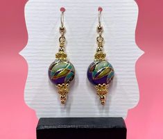 These Tensha purple mosaic earrings have a vintage feel to them. I accented the Tensha beads with gold vermeil spacer beads, gold vermeil bead caps and small round gold filled beads. They measure approximately 1 3/4 inches from the top of the gold filled earwire. Please note that images are enlarged to show detail. Click here to see other earrings in my shop: https://www.etsy.com/shop/JewelryDesignsByRita?section_id=14765680 I have been designing and making jewelry since 2010. I use only the hig Artisan Gold Earrings With Dangling Beads, Gold Czech Glass Beaded Earrings, Gold Earrings With Spacer And Round Beads, Festive Earrings With Gold Beads, Festive Gold Beaded Earrings With Round Beads, Artisan Gold Beaded Earrings, Gold Beaded Czech Glass Earrings, Gold Round Beaded Earrings With Spacer Beads, Gold Beaded Earrings With Czech Glass