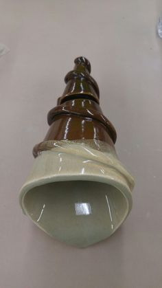 a brown and white vase sitting on top of a table