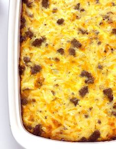 a casserole dish with meat and cheese in it on a white table top