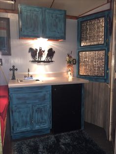 a kitchen with blue cabinets and an area rug