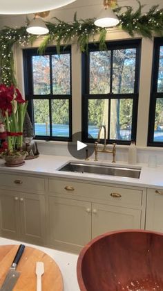 the kitchen is decorated for christmas with wreaths on the window sill and flowers