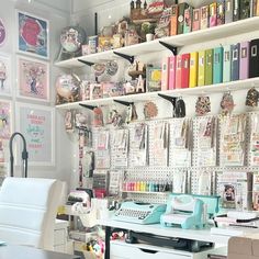 a desk with a typewriter, phone and many books on the wall behind it