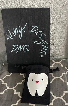 a toothbrush holder sitting on top of a bed next to a chalkboard sign