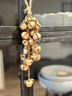 a bunch of bells hanging from the side of a wooden pole in front of a toilet