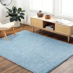 a blue rug in a living room with a chair and coffee table on the floor