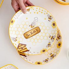 a plate with bees and honey on it is being held by someone's hand