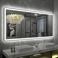 a bathroom with two sinks and a large mirror above the sink is illuminated by lights