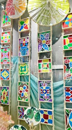 there are many colorful items on display in the store window with umbrellas hanging from them