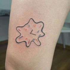 a small clock tattoo on the leg of a woman's thigh, with writing all over it