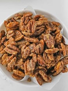 a white bowl filled with pecans on top of a table